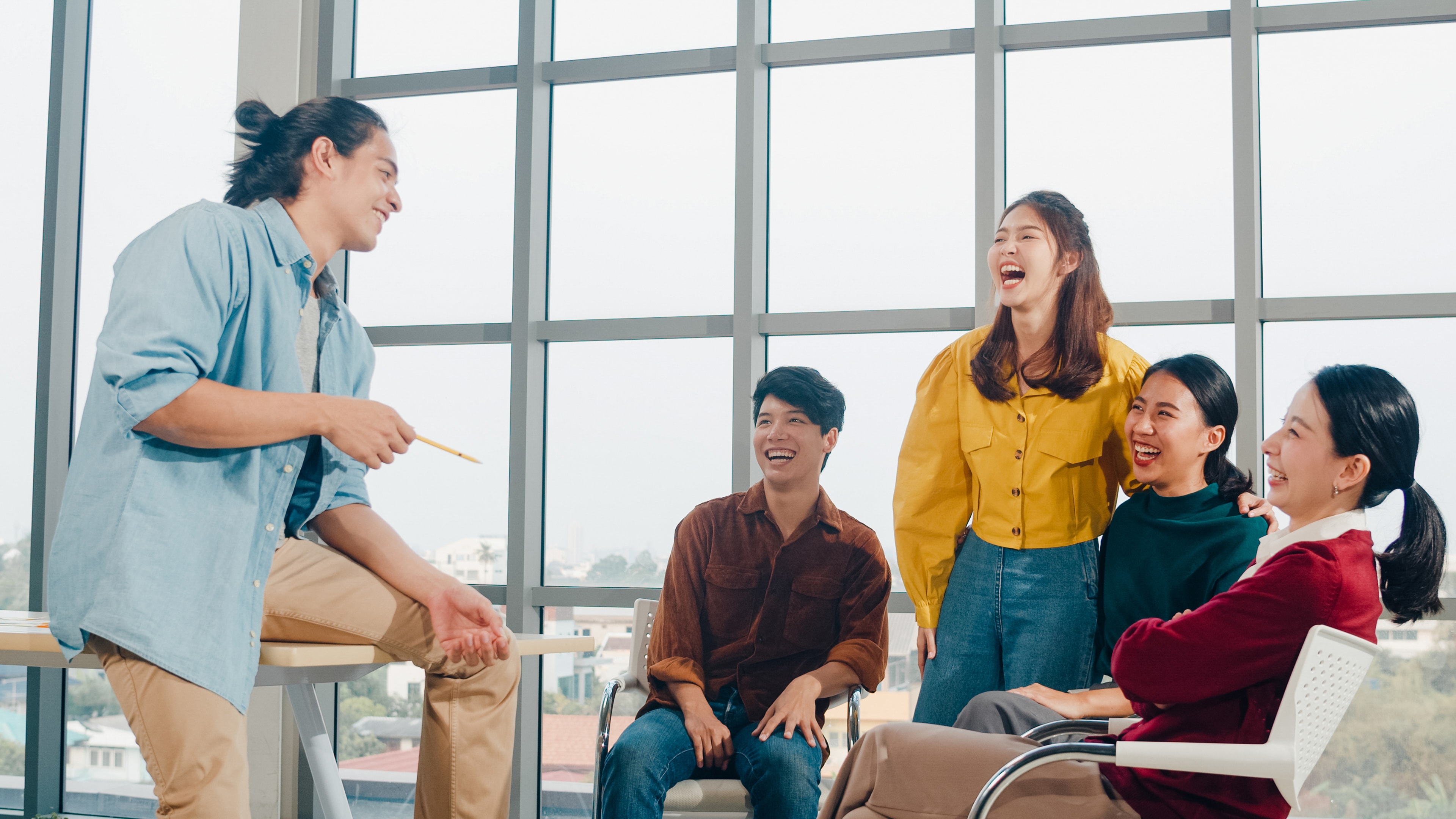Young adults laughing and engaging in a group English speaking class
